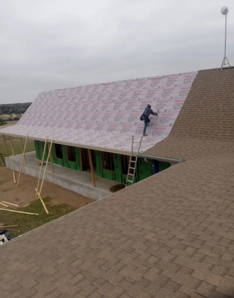 Worker preparing underlayment for a metal roof installation in Palm River-Clair Mel